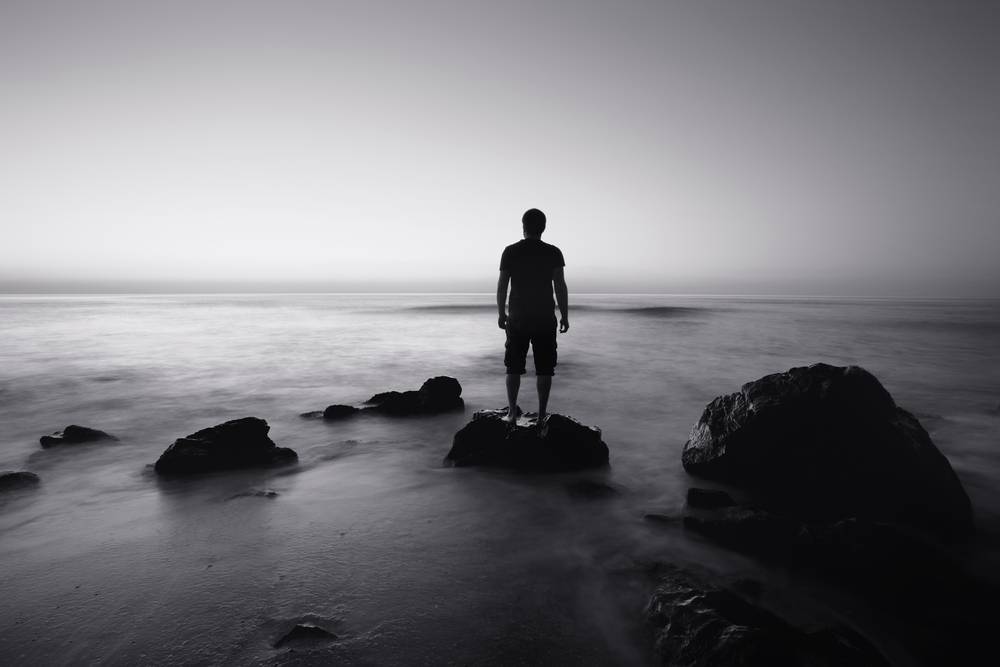 A call to all good men: man standing on rock in front of ocean