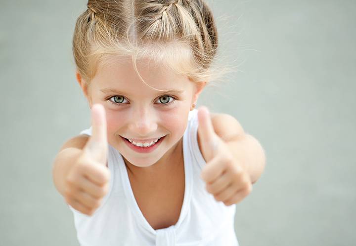 How to build your child's self esteem: little girl gives thumbs up